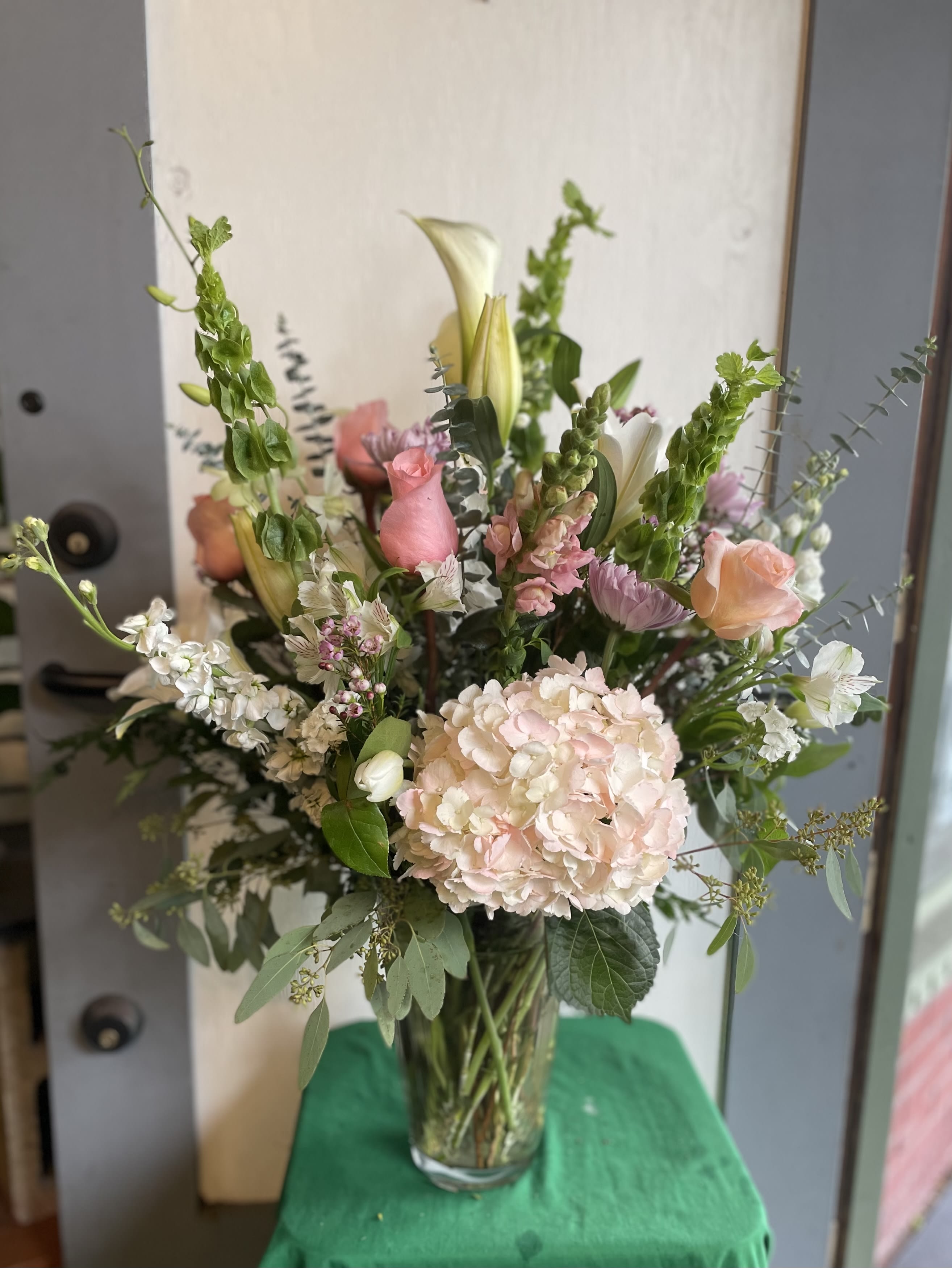 Tall mixed bouquet in a clear glass vase with pink and white flowers