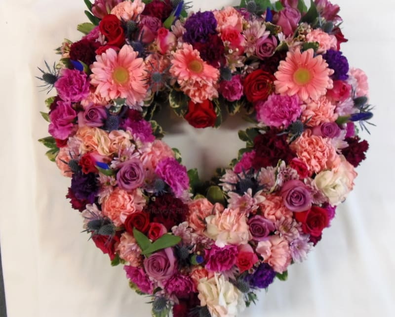 Heart-shaped floral wreath with pink, red, and purple blooms