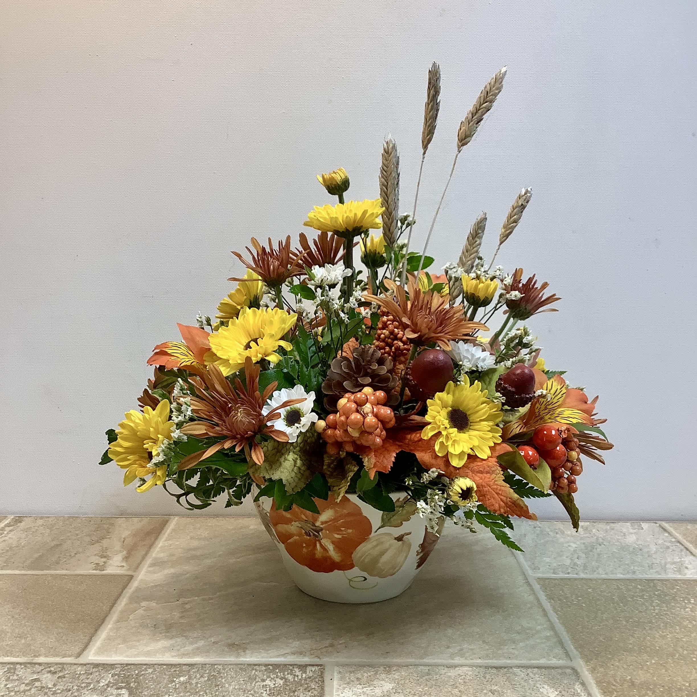 Autumn flower arrangement in a painted ceramic vase with yellow and orange blooms