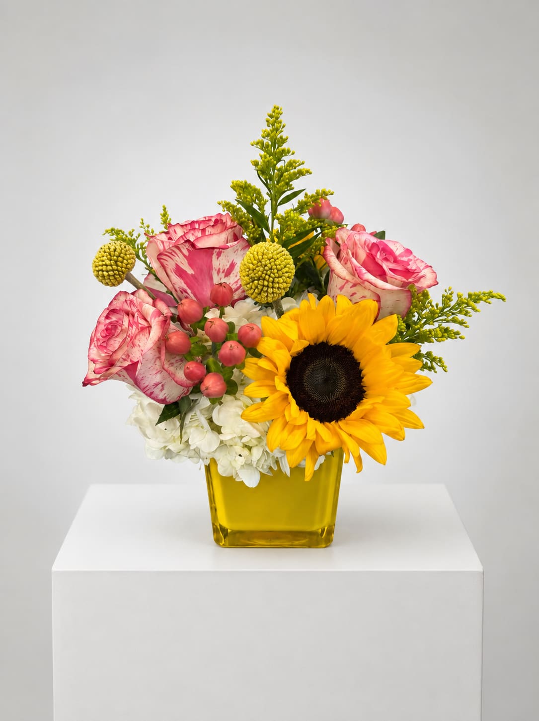 Bouquet of pink roses and a sunflower in a yellow vase