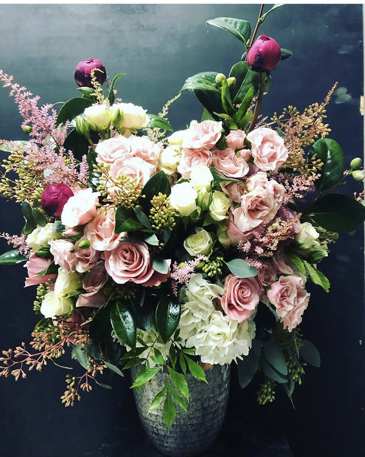 Pink and white rose arrangement in a gray vase