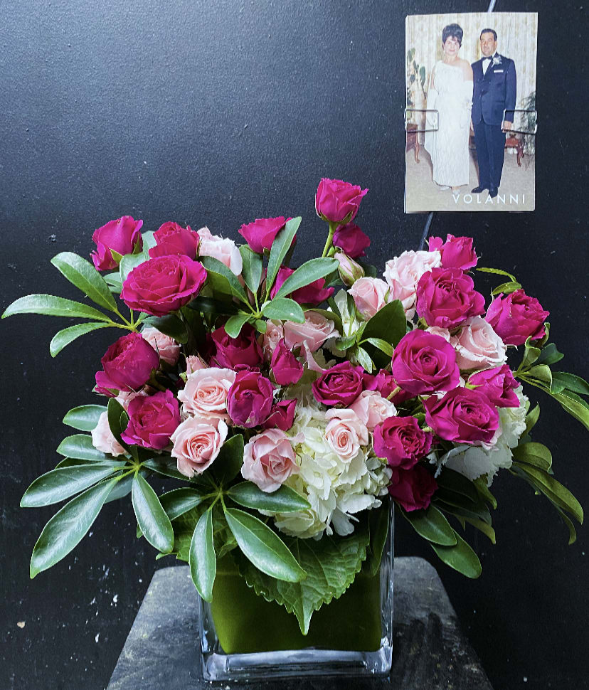 Pink and pale roses arranged in a clear square vase