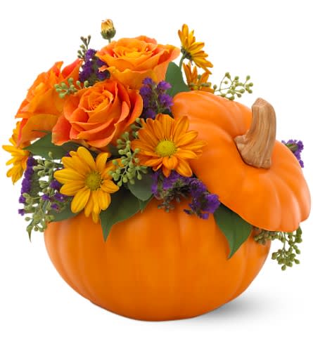 Orange roses and daisies arranged in a pumpkin container