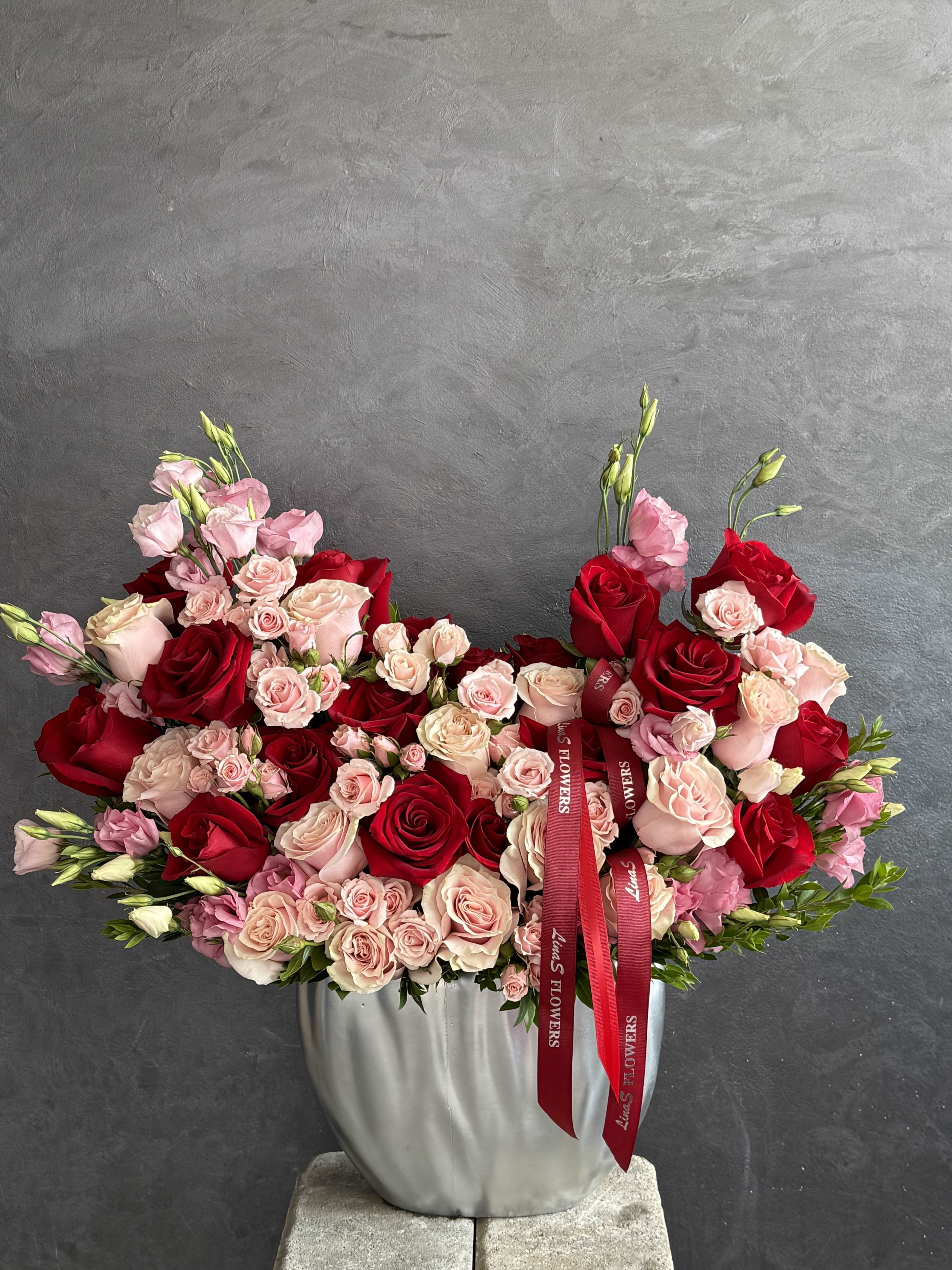 Large bouquet of red and blush roses in a silver vase