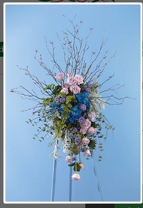 Tall floral arrangement with pink and blue flowers on a stand
