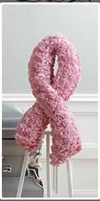 Pink floral ribbon-shaped standing arrangement on an easel