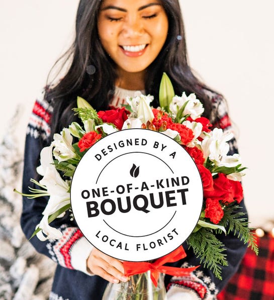 Woman holding a red and white bouquet with lilies and carnations