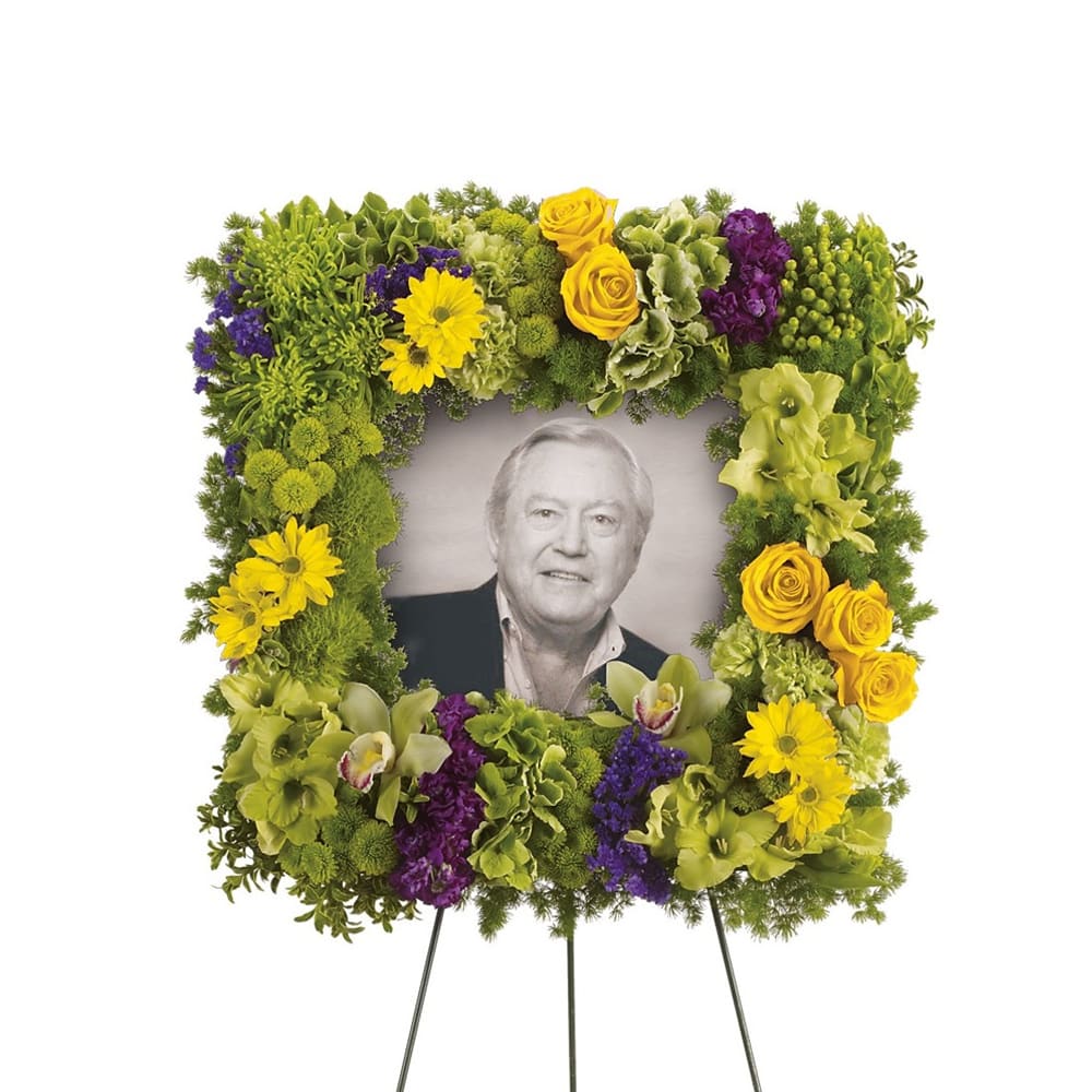 Square floral funeral frame around a portrait on an easel