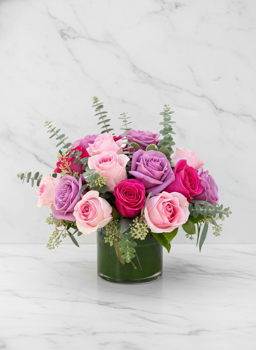 Modern Pink and Purple Roses - Chic and romantic, Modern Pink and Purple Roses blends soft blush, lavender, and vibrant hot pink blooms into a stunning contemporary arrangement. Designed in a sleek glass vase with fresh eucalyptus accents, this bouquet brings timeless beauty with a modern edge — perfect for birthdays, anniversaries, or simply brightening someone’s day.  Elegant. Feminine. Designed with love in San Francisco by Polk Street Florist.