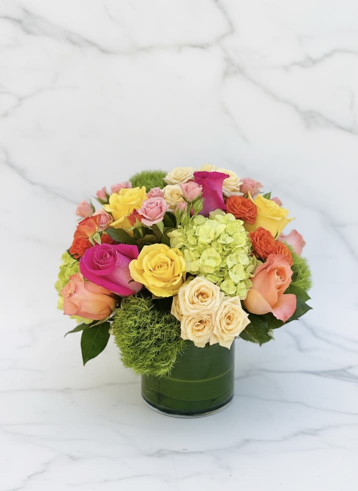 Colorful rose bouquet in a green glass vase