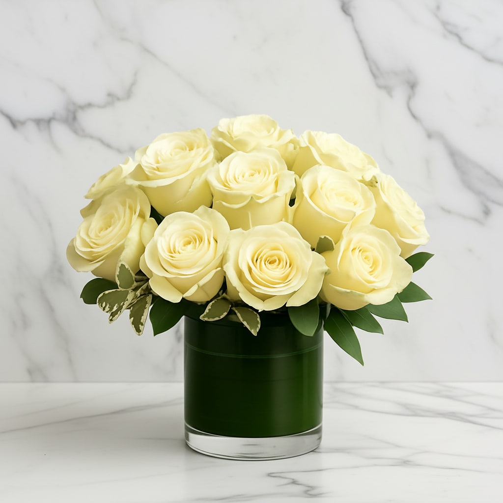 Cream roses arranged in a dark green glass vase