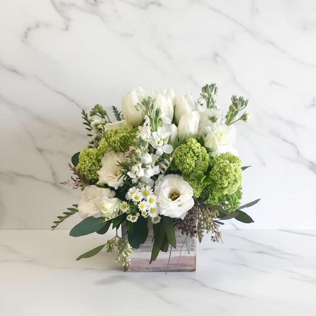 White and green floral arrangement in a wooden box