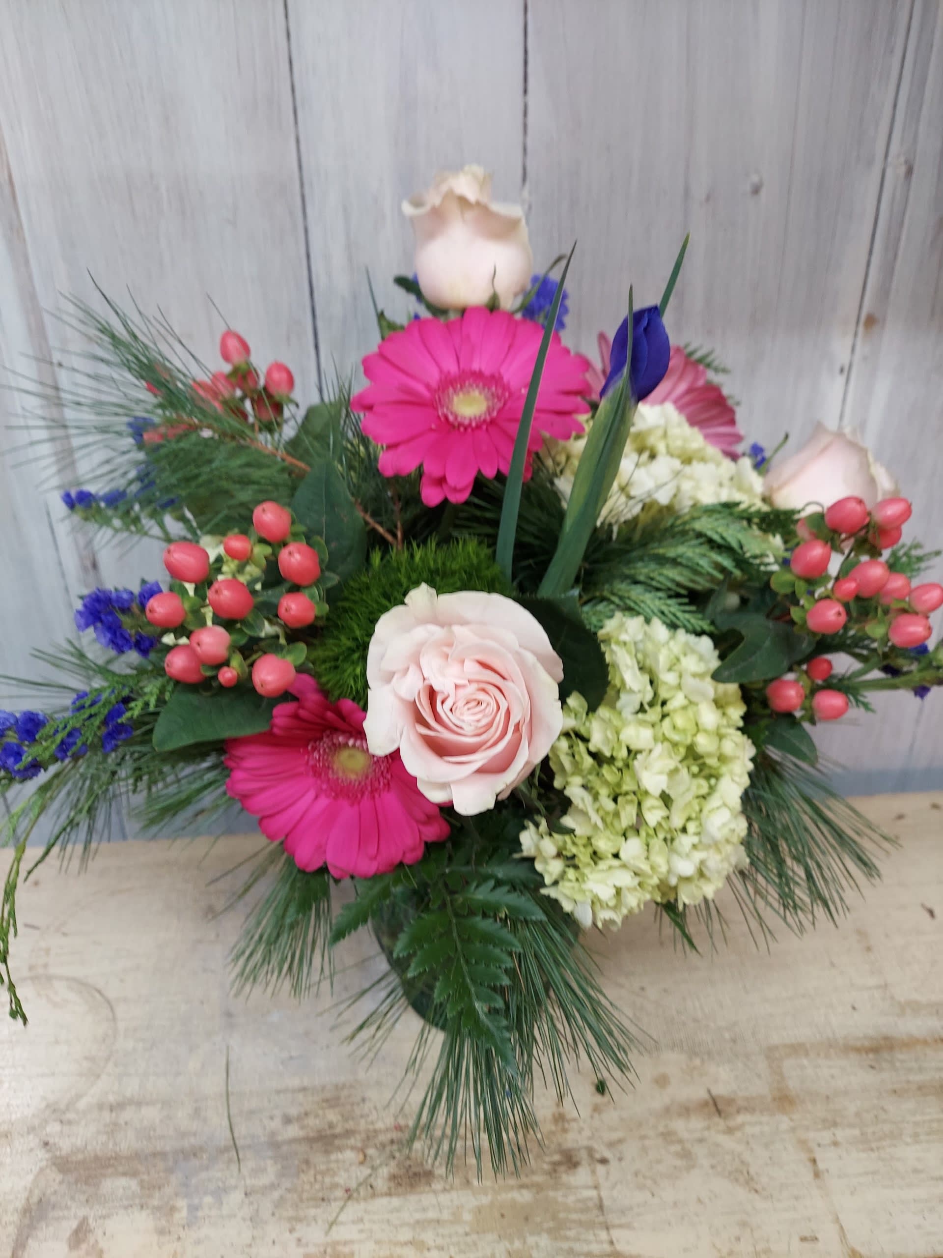 Pink roses and gerbera daisies in a mixed floral arrangement