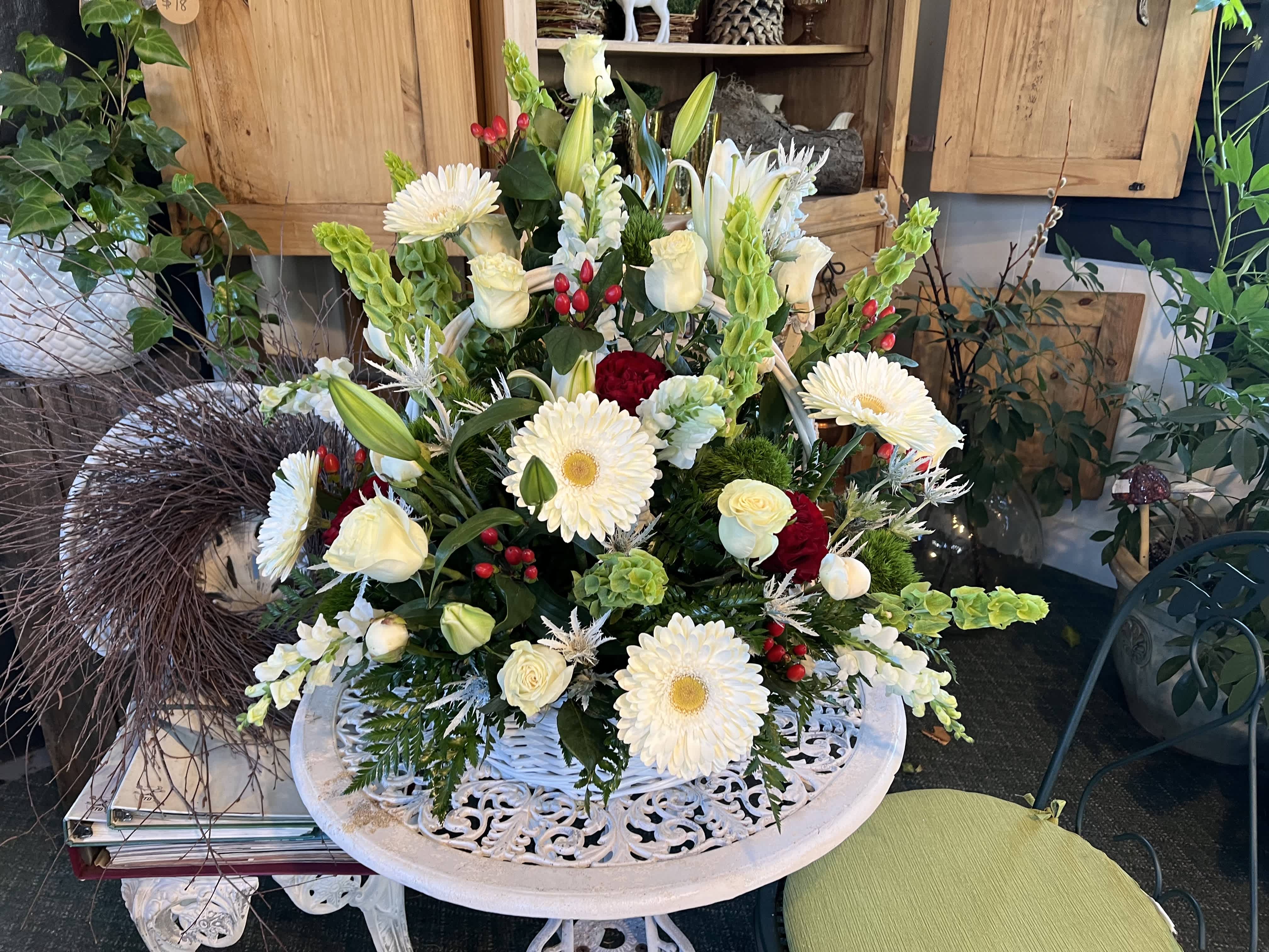 Large white floral arrangement with daisies, roses, and lilies in a decorative bowl