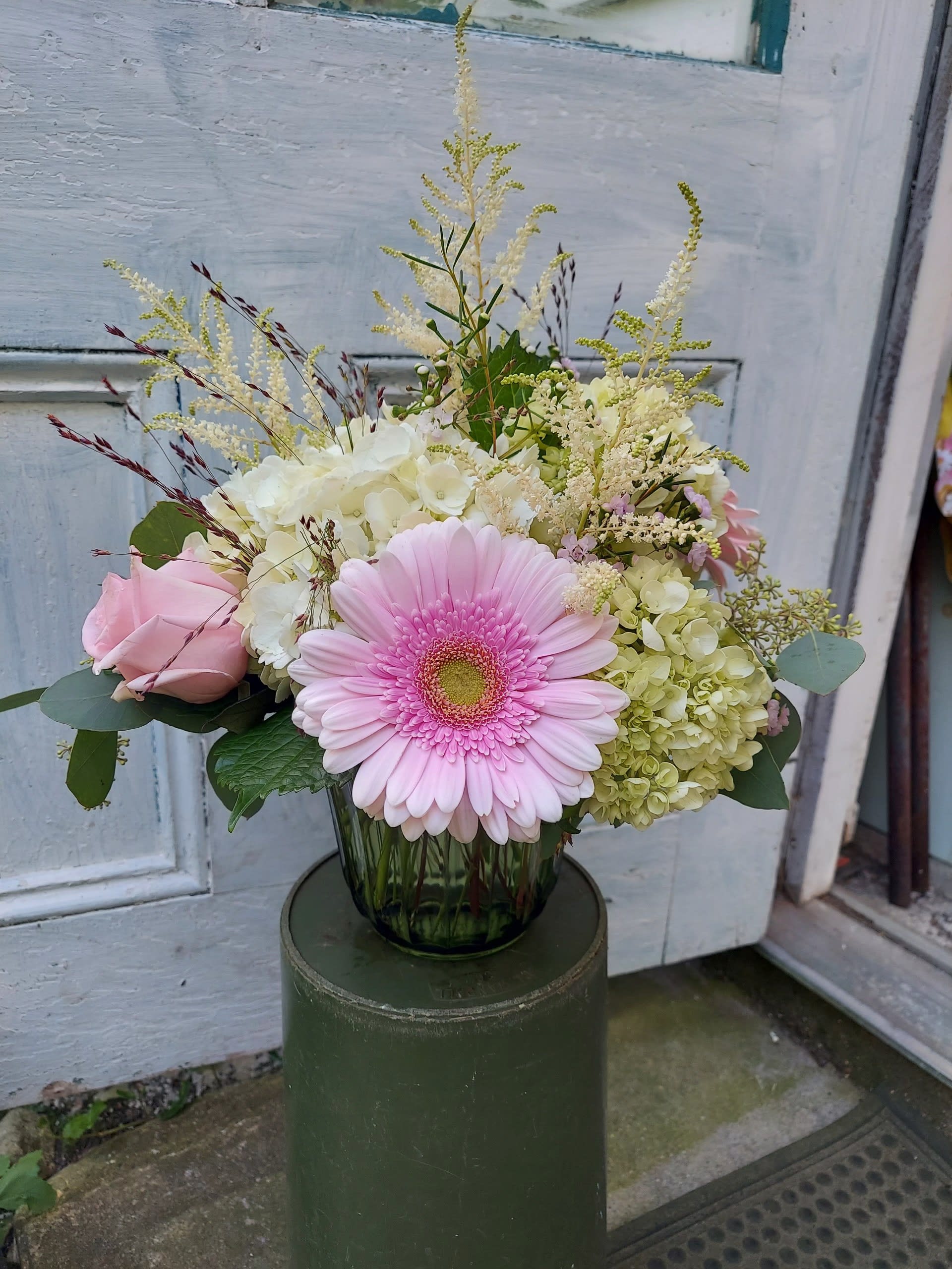 Pink gerbera daisy and roses in a glass vase