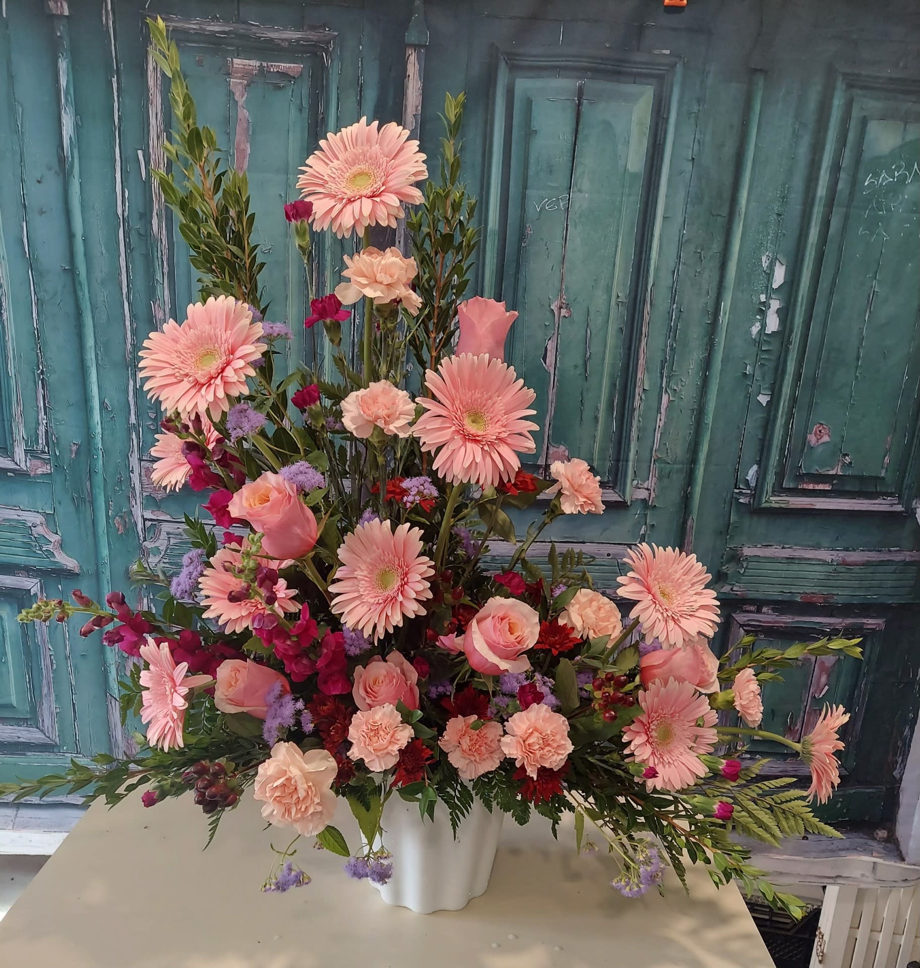 Large pink floral arrangement in a white vase