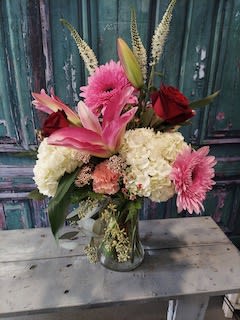 Pink lilies, roses, and hydrangeas in a glass vase