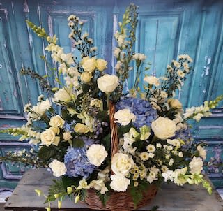 Large basket arrangement of white and blue flowers