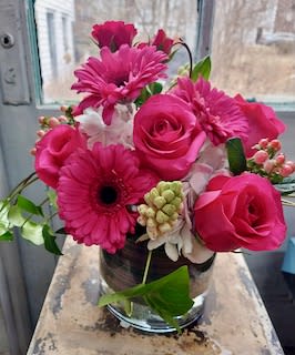 Pink roses and gerbera daisies arranged in a glass vase