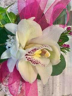 White orchid bouquet with pink ribbon and green leaves