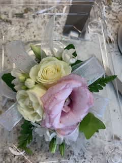 Small bouquet of white and pink flowers wrapped in clear ribbon