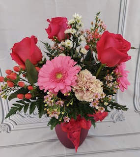 Pink and red flower arrangement in a red vase