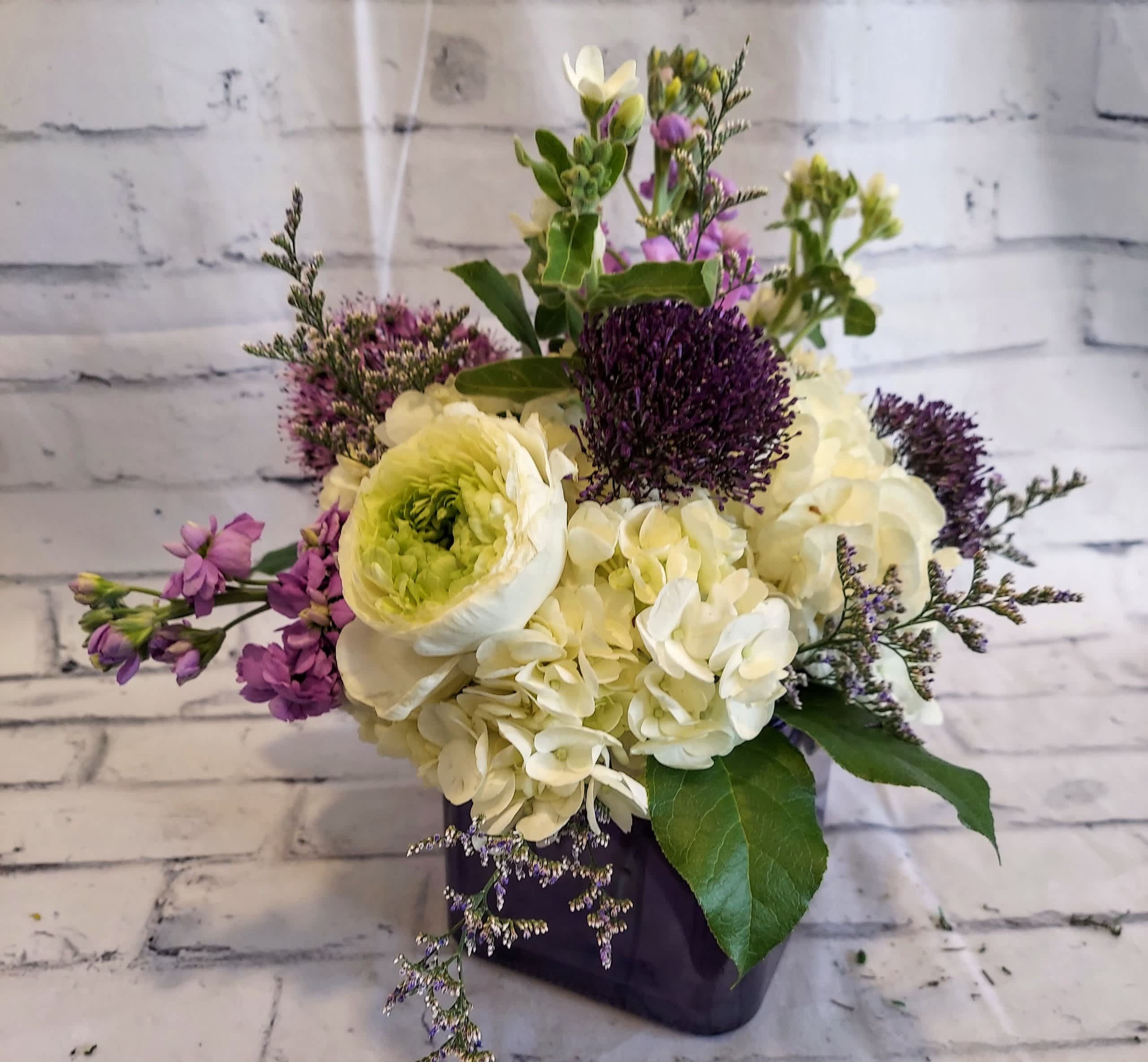 Bouquet of white and purple flowers in a dark vase