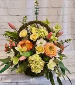 Floral wreath with mixed blooms in yellow, peach, pink, and white