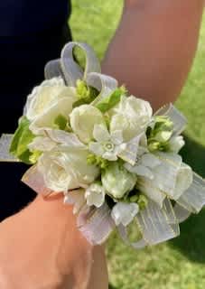 White rose corsage with ribbon on a wrist