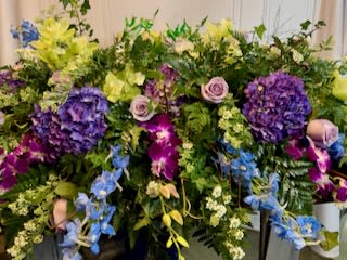 Large mixed floral spray with purple, yellow, blue, and pink blooms