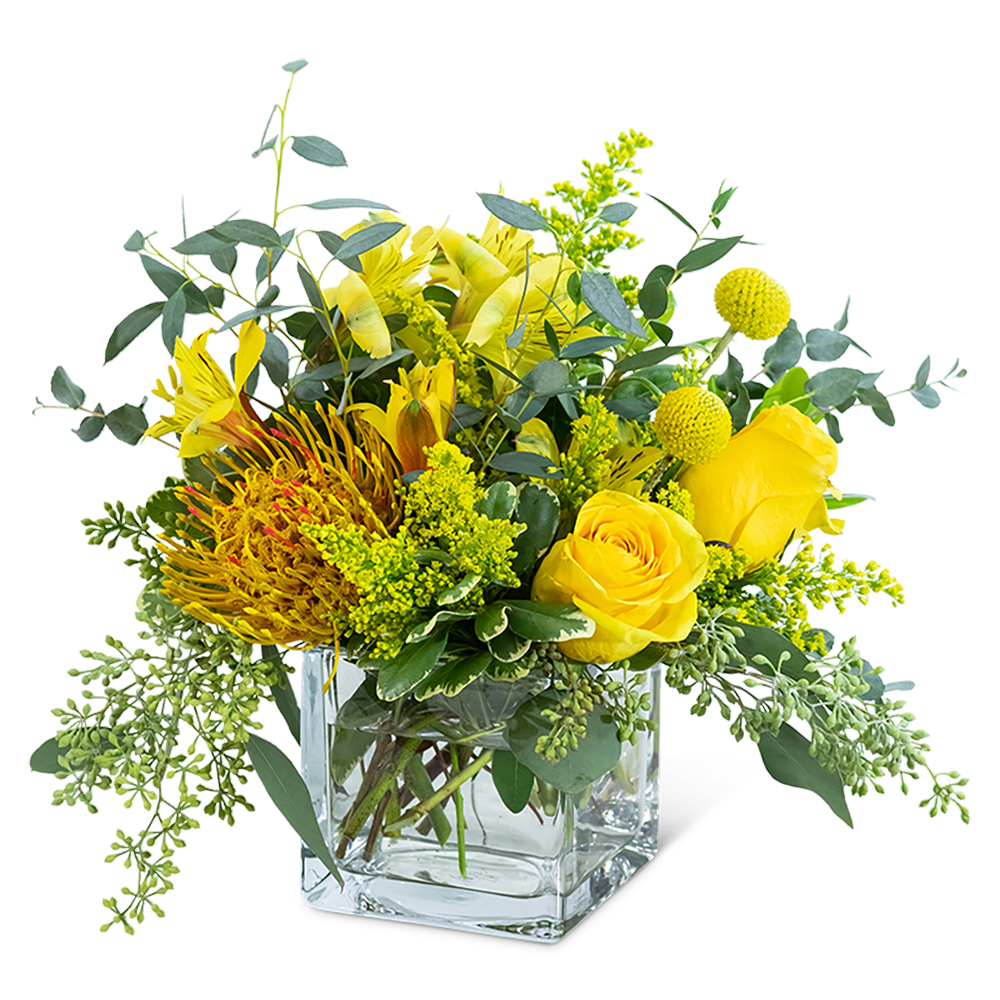 Yellow floral arrangement in a clear square glass vase