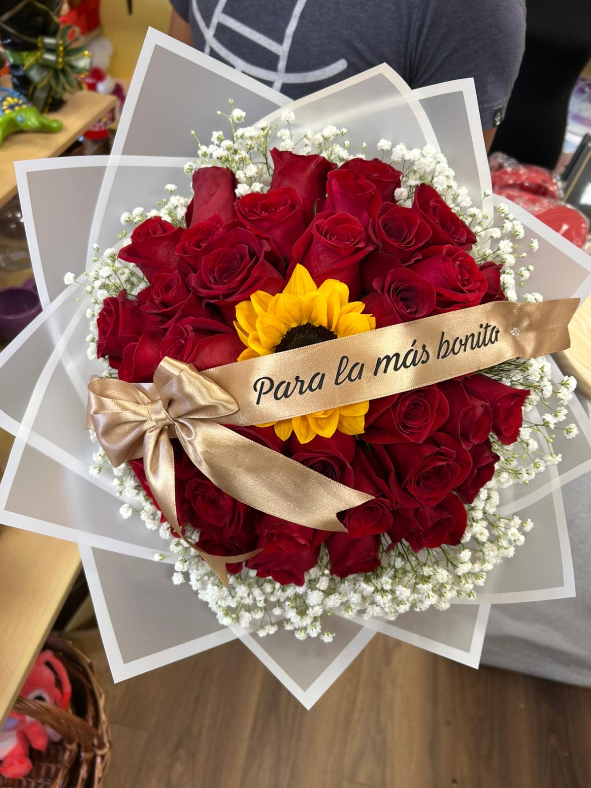 Bouquet of red roses with a yellow sunflower and white baby's breath