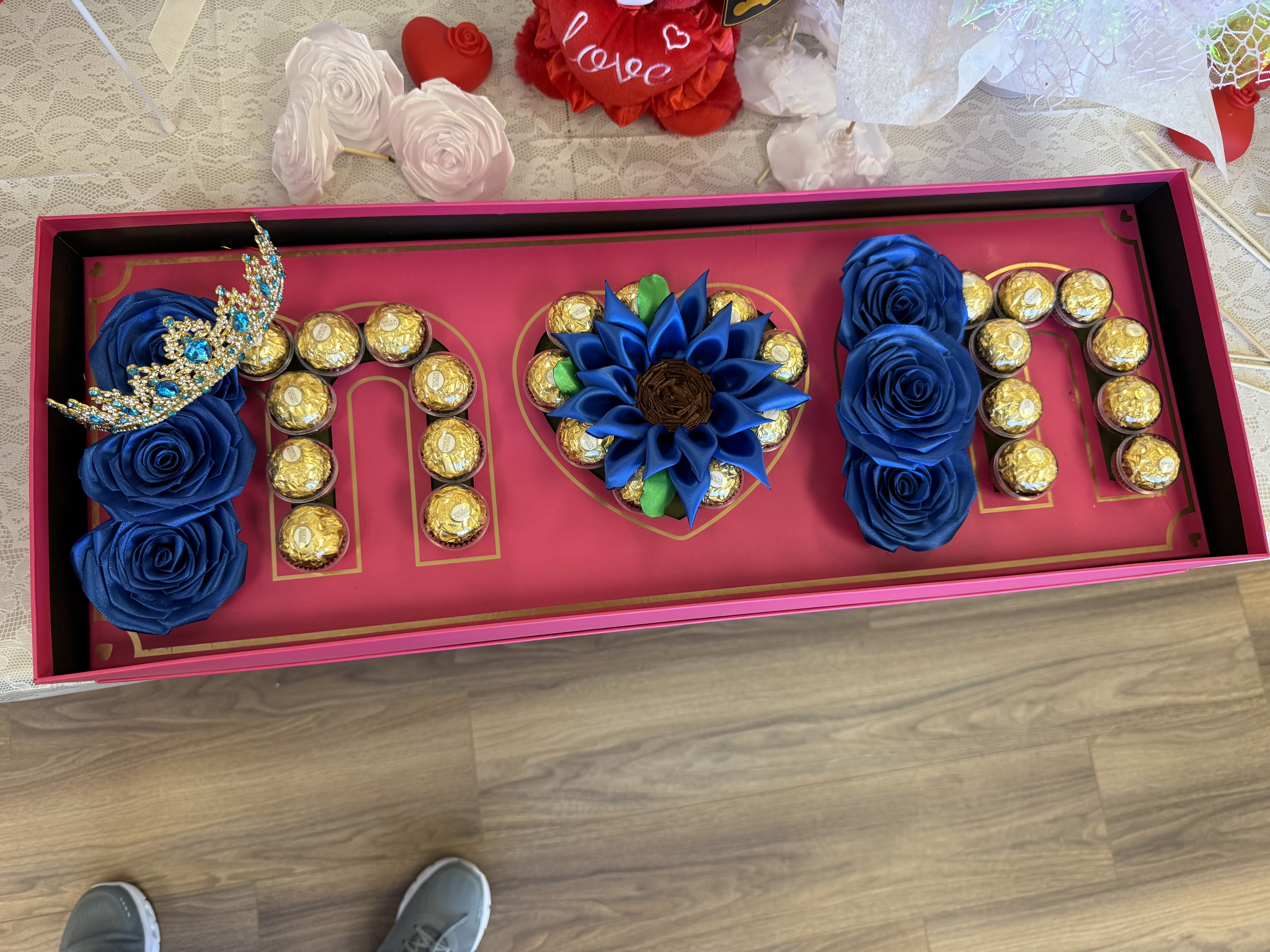 Decorative gift box with blue roses and chocolates arranged in letters