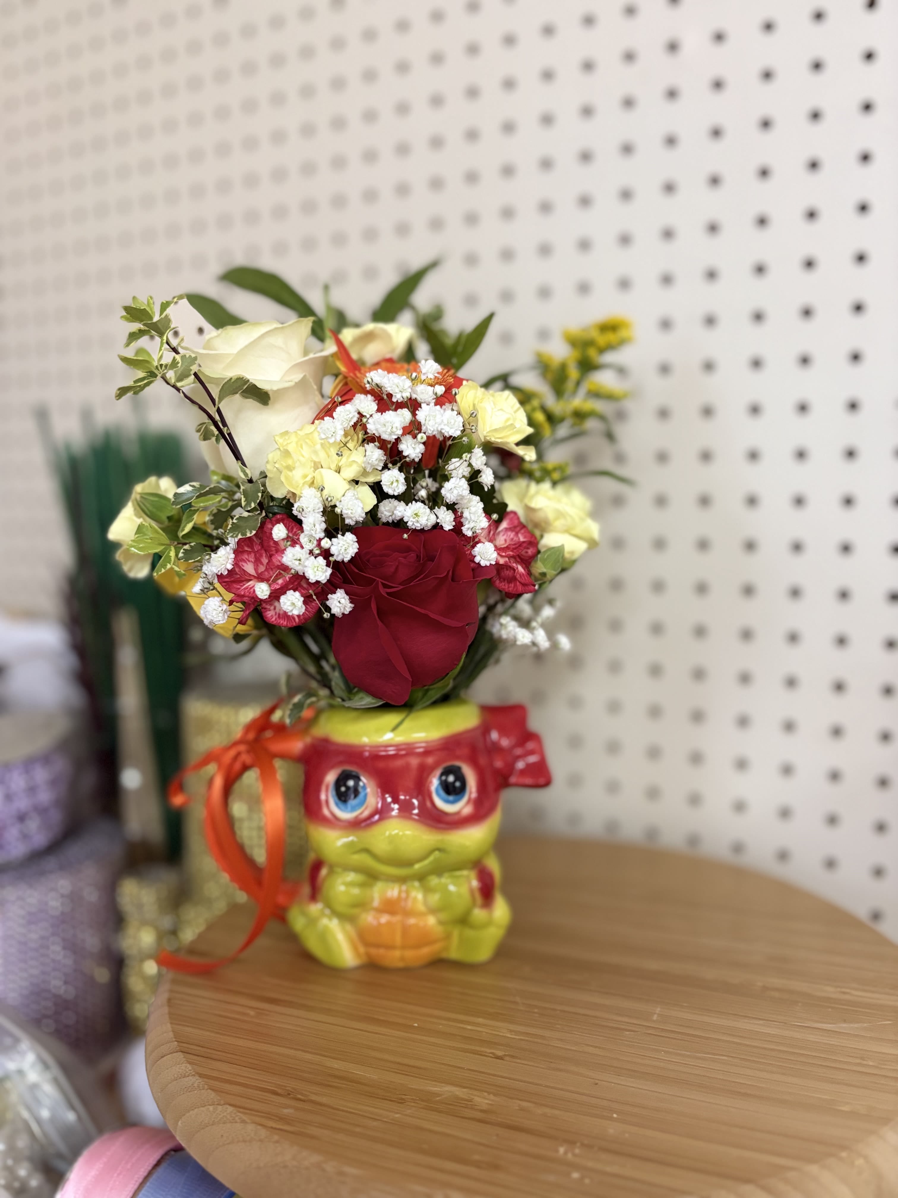 Red and cream roses in a novelty ceramic pot