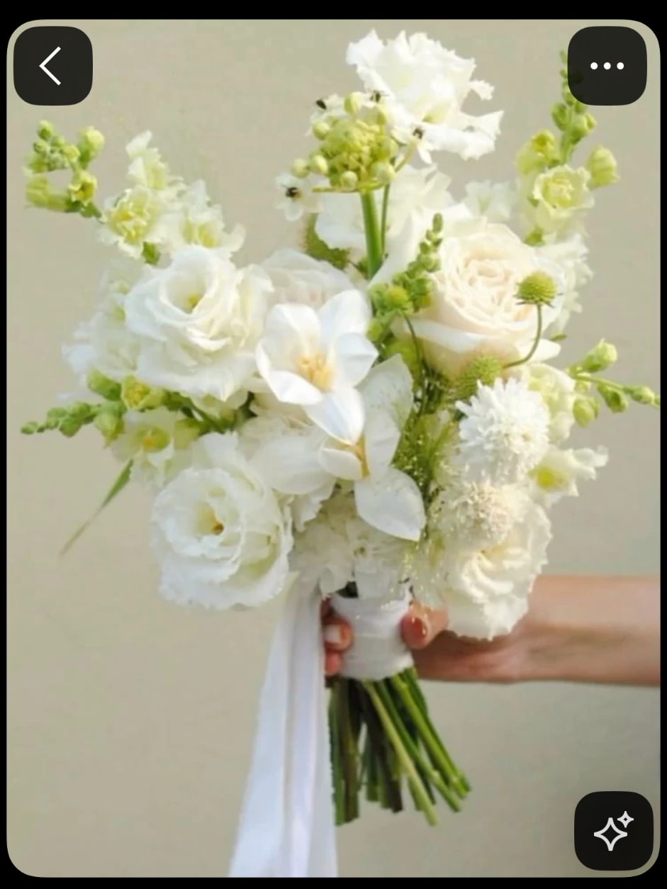 White bridal bouquet with roses and orchids tied with a ribbon