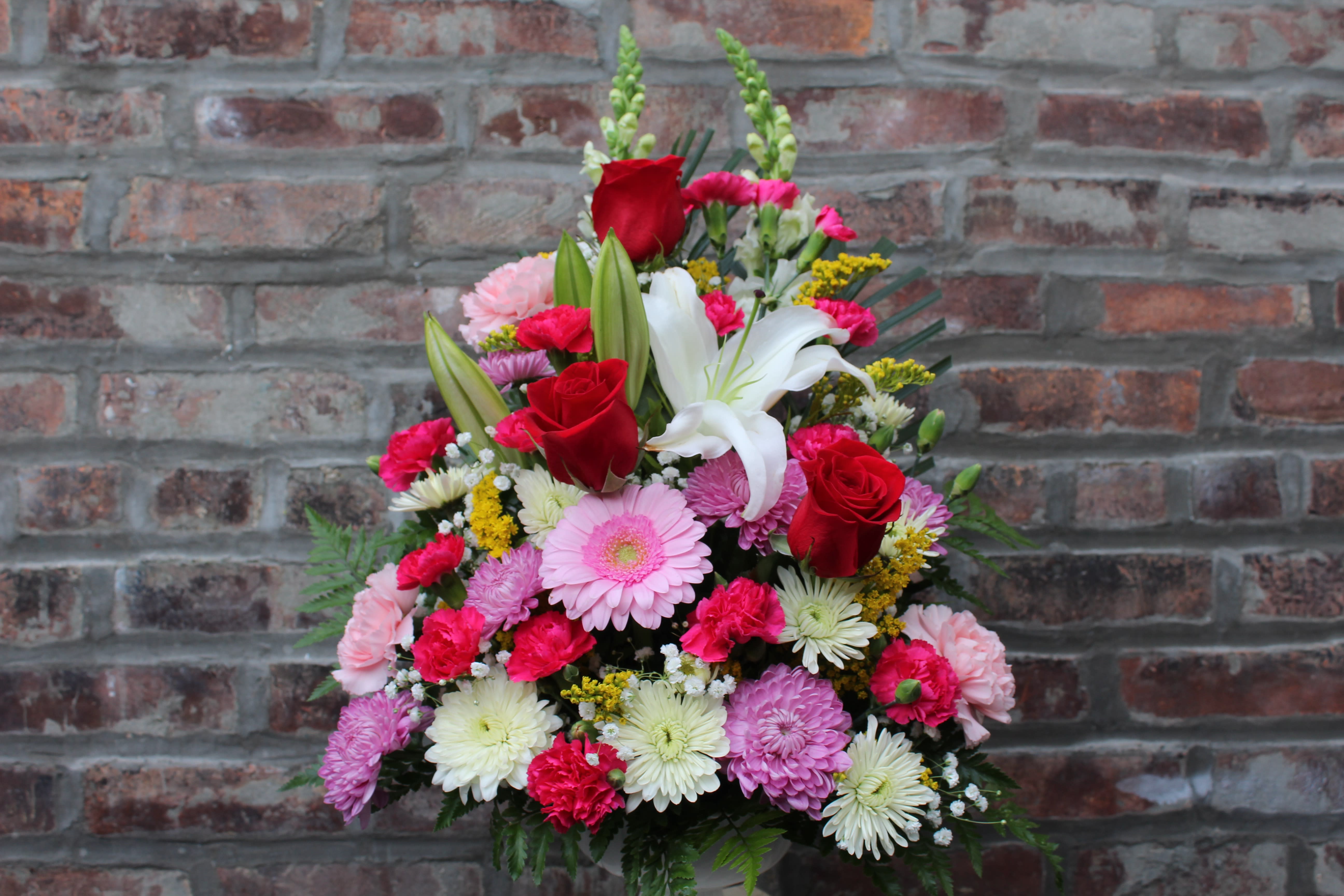 Mixed bouquet with red roses, white lilies, and pink daisies