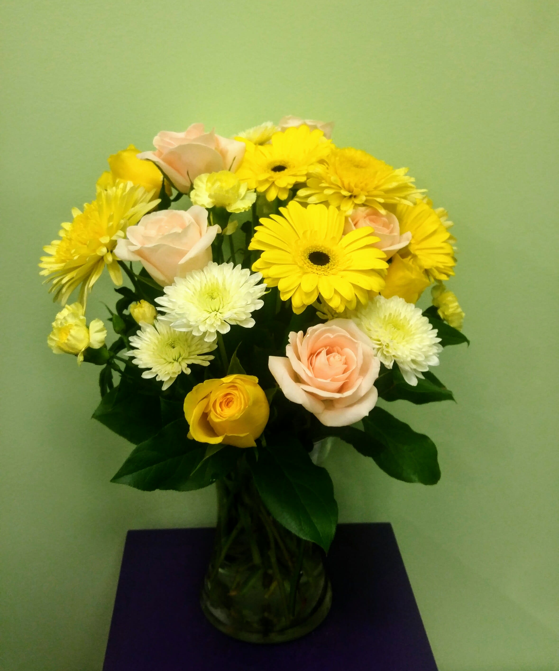 Bouquet of yellow and pale pink flowers in a glass vase