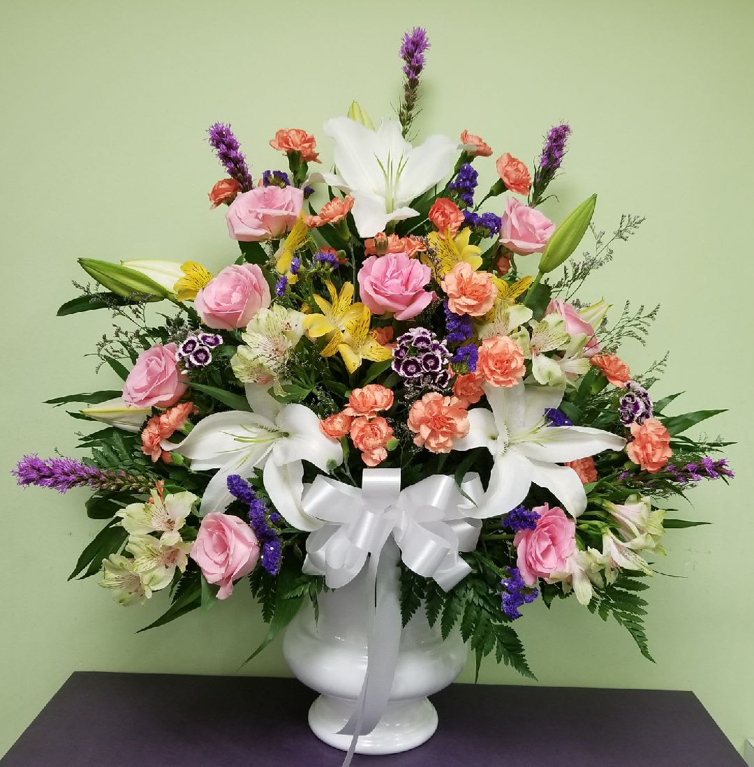 Mixed bouquet in a white vase with pink roses and white lilies