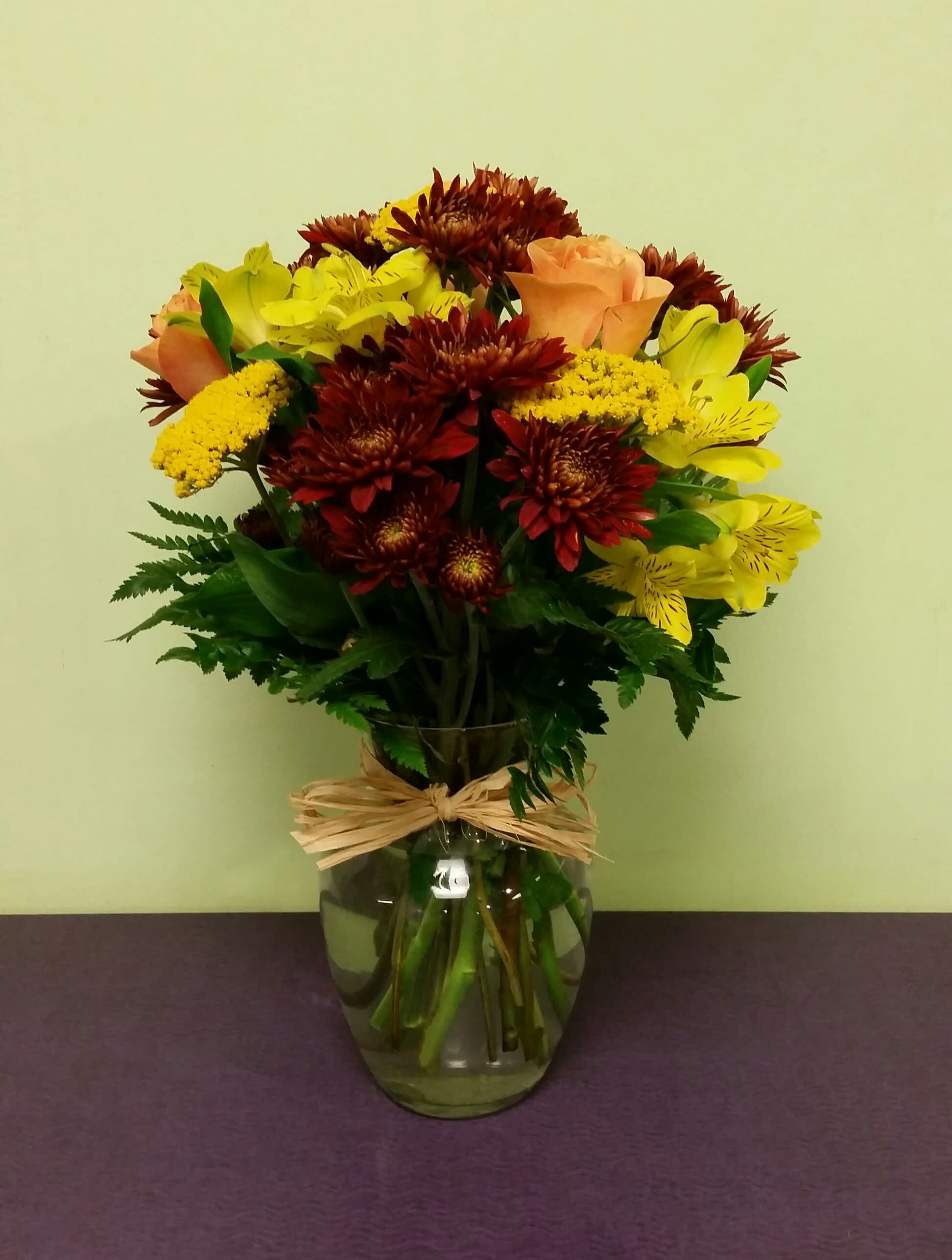 Bouquet of yellow and peach flowers in a glass vase