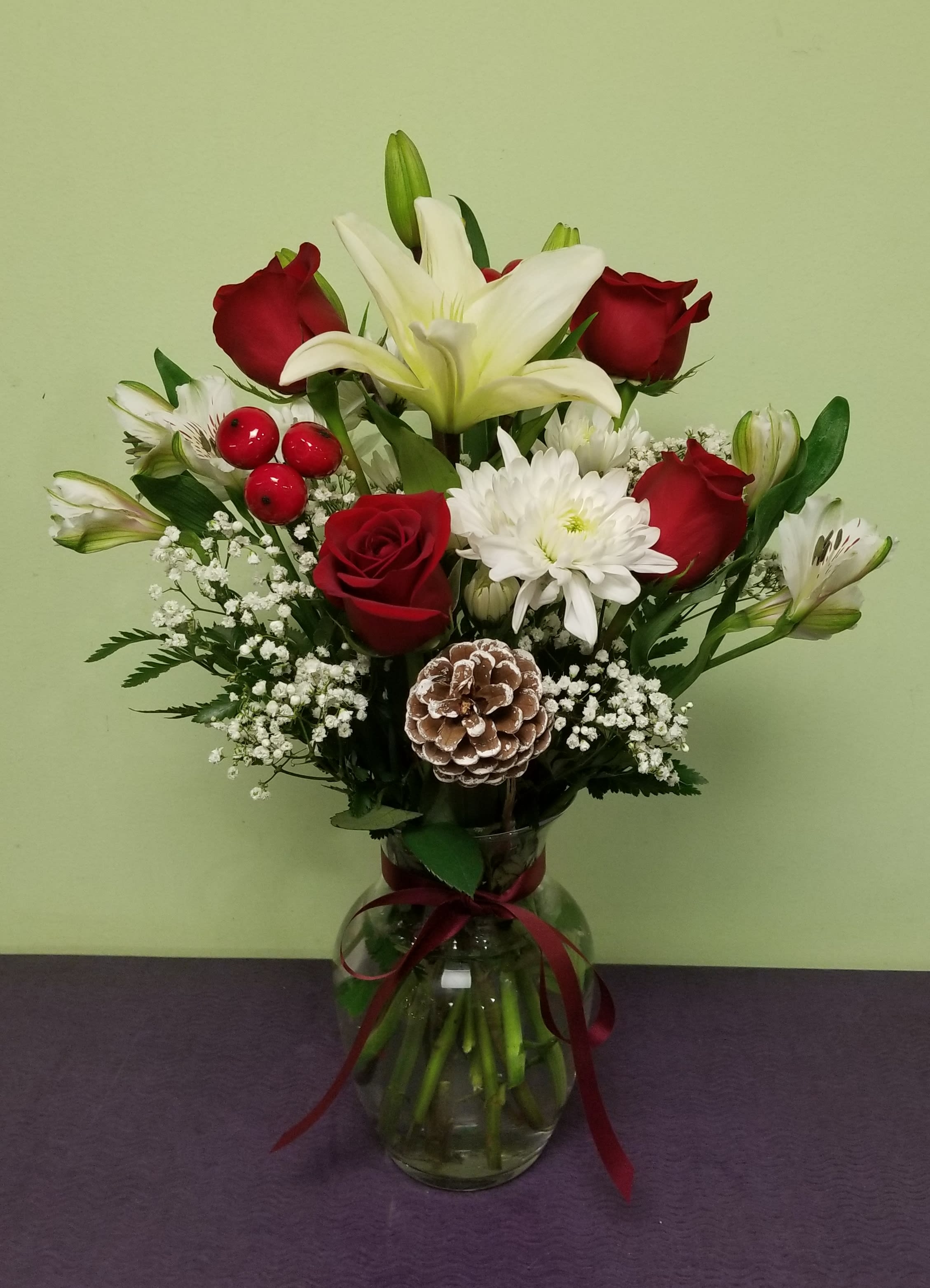 Bouquet of red roses and white lilies in a glass vase