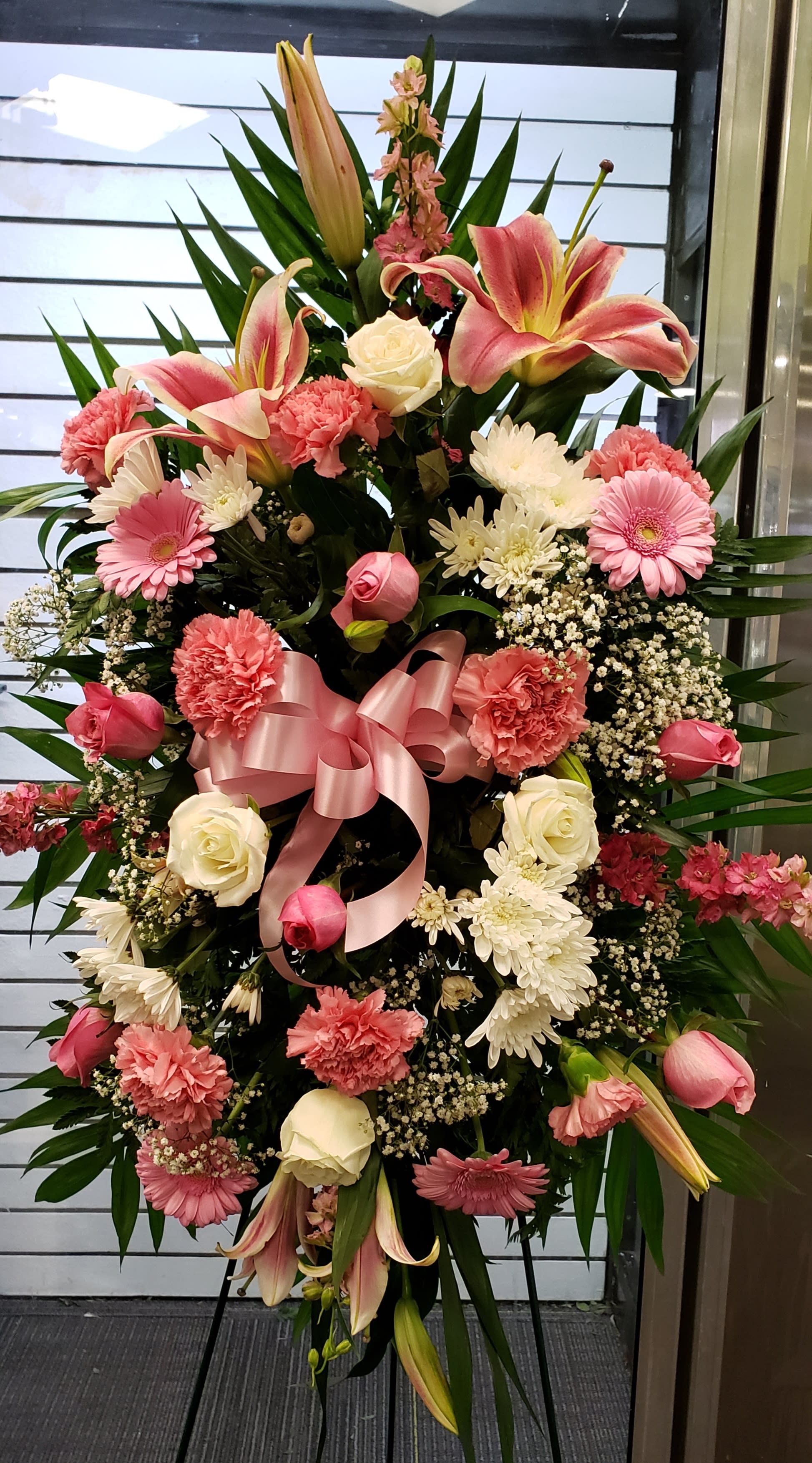 Standing floral spray with pink lilies, roses, and carnations