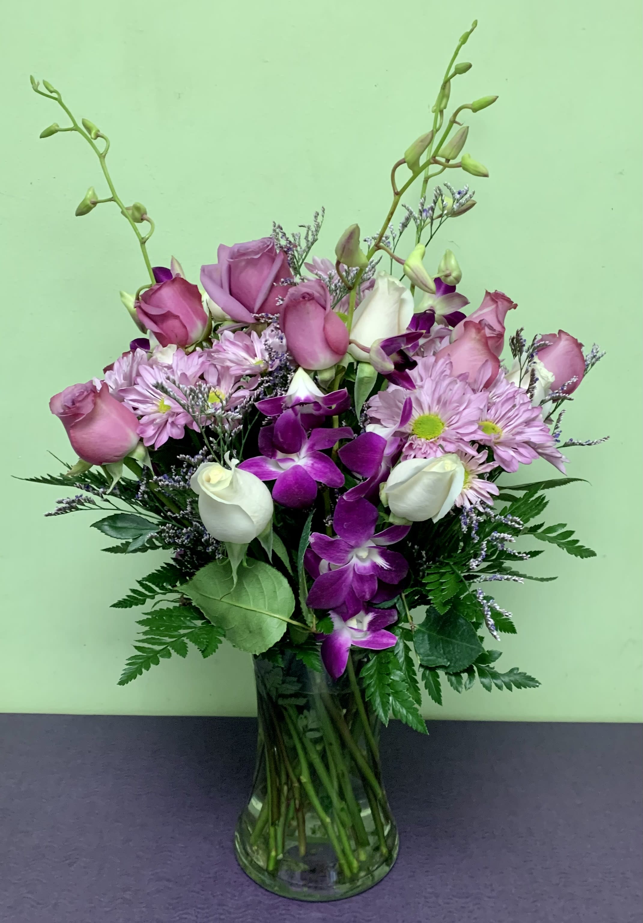 Pink roses and purple orchids in a glass vase