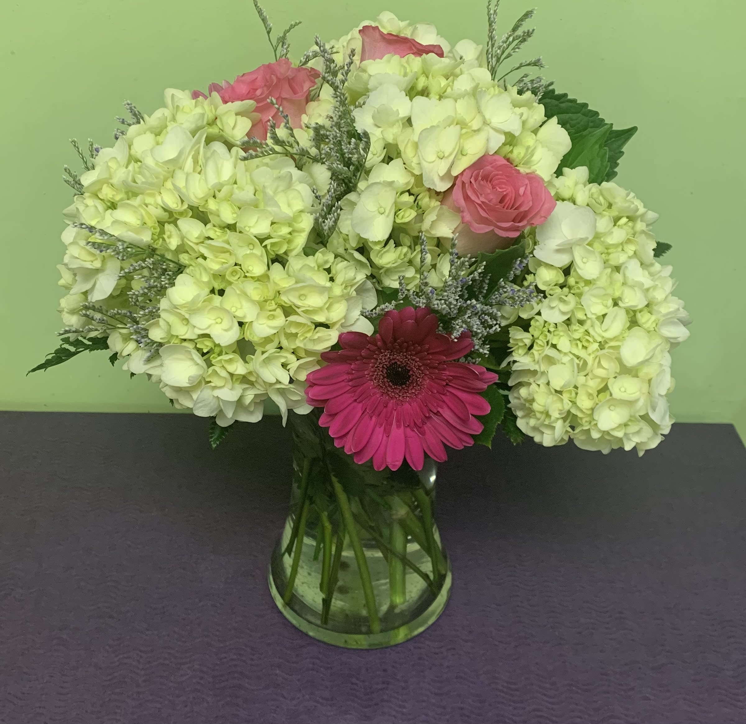 Pink and white flowers arranged in a glass vase