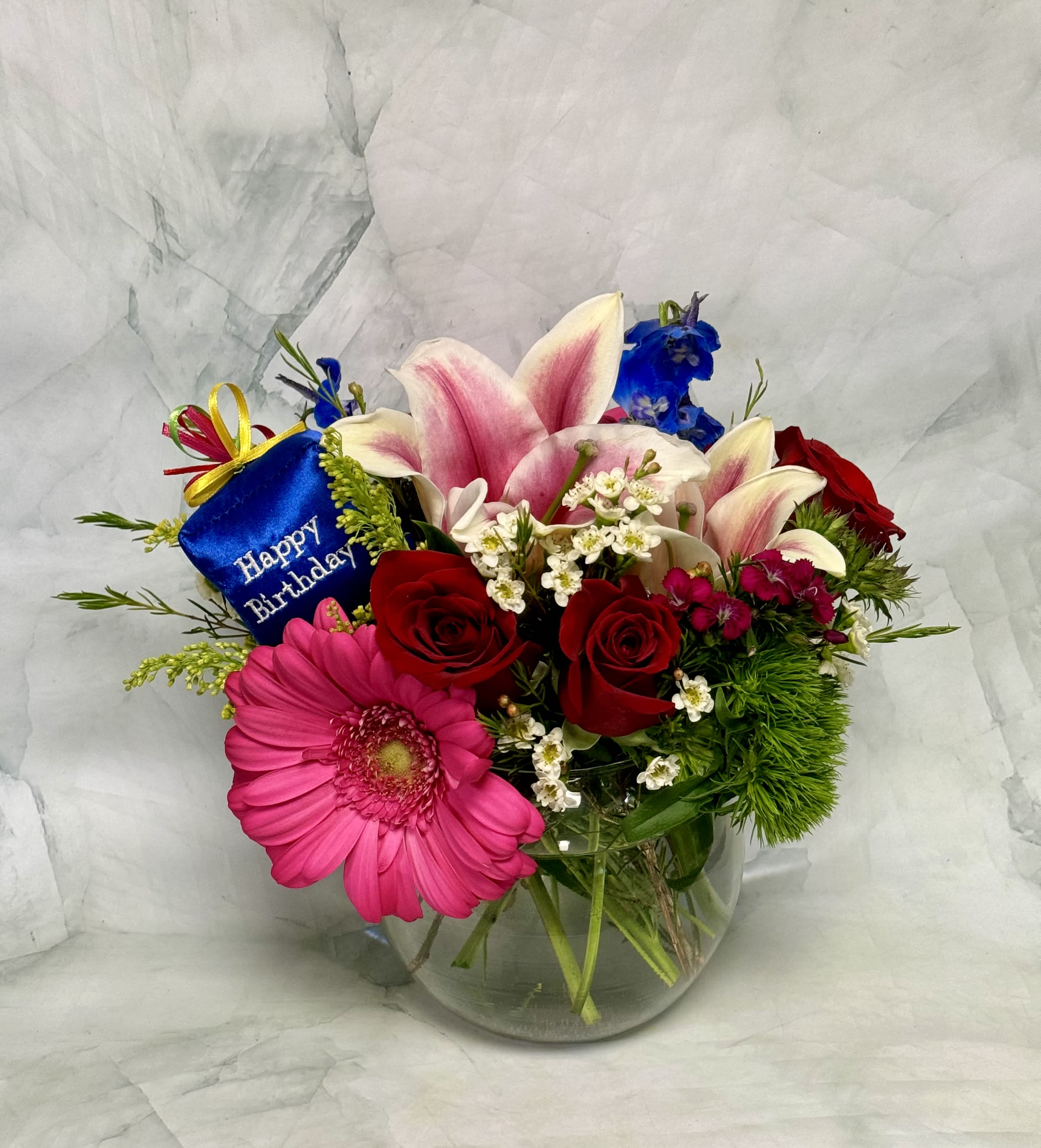 Mixed bouquet in a glass vase with a birthday tag