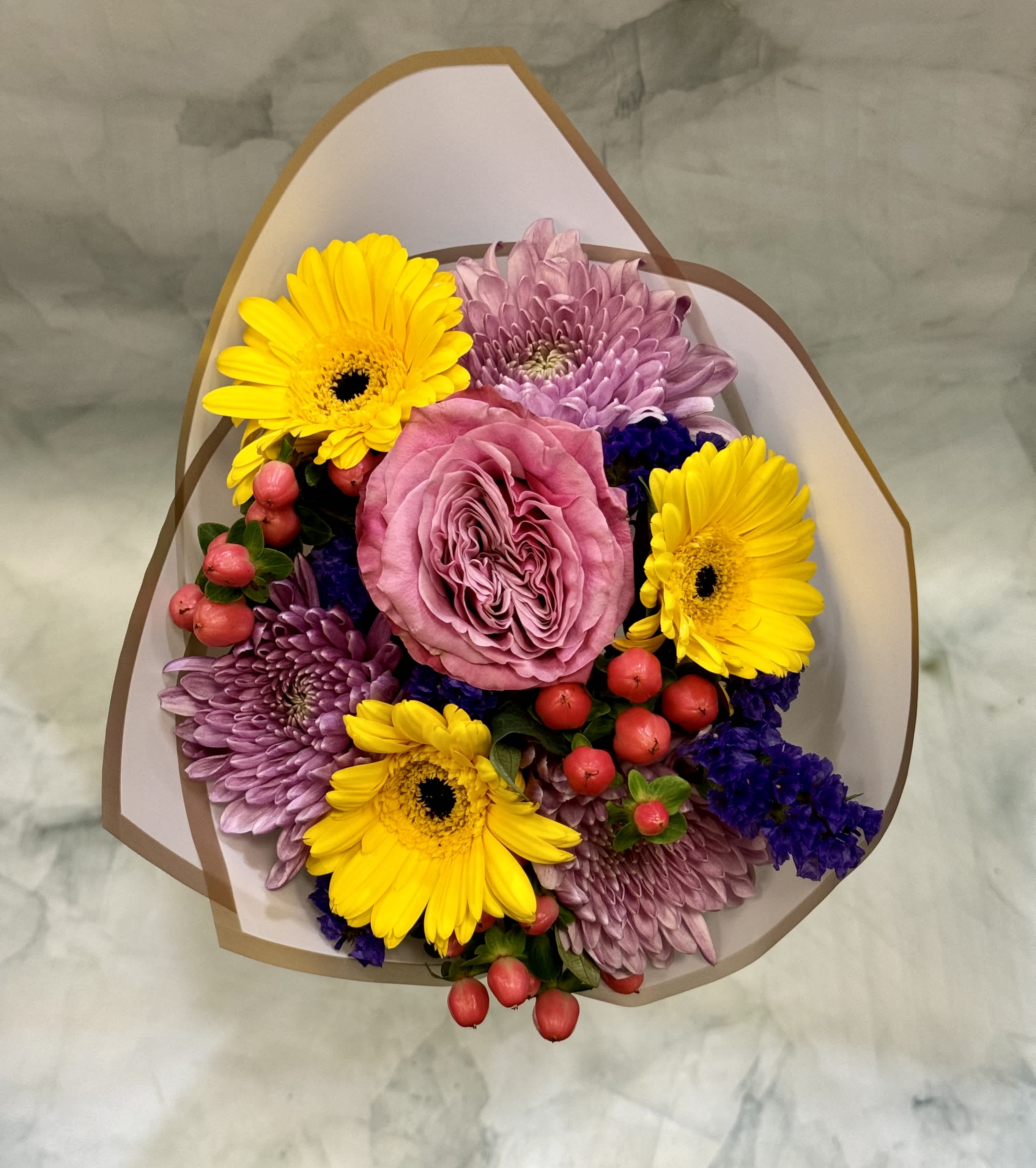 Bouquet of pink roses, yellow gerbera daisies, and purple chrysanthemums