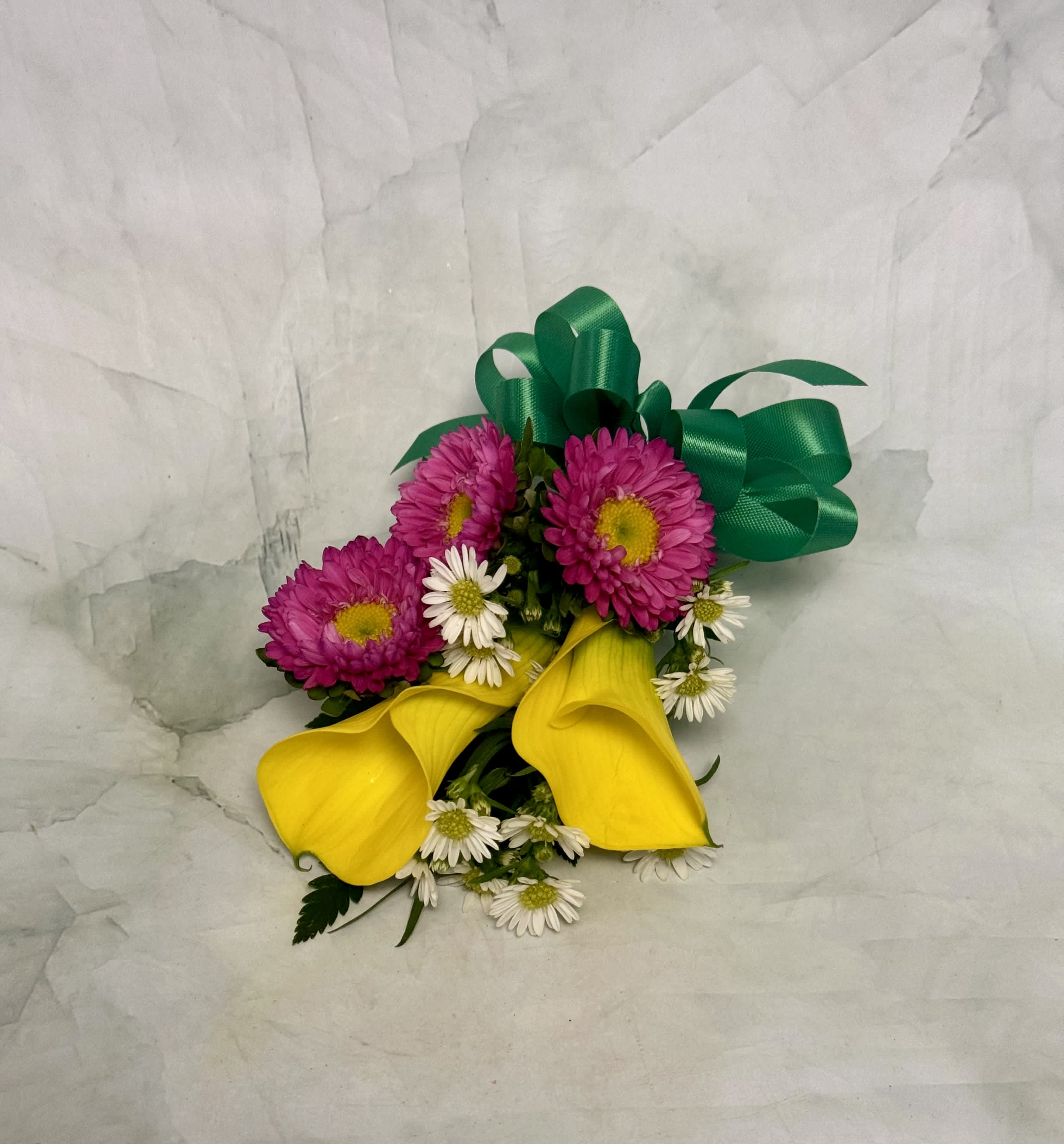 Bouquet with yellow calla lilies, pink daisies, and white daisies tied with green ribbon