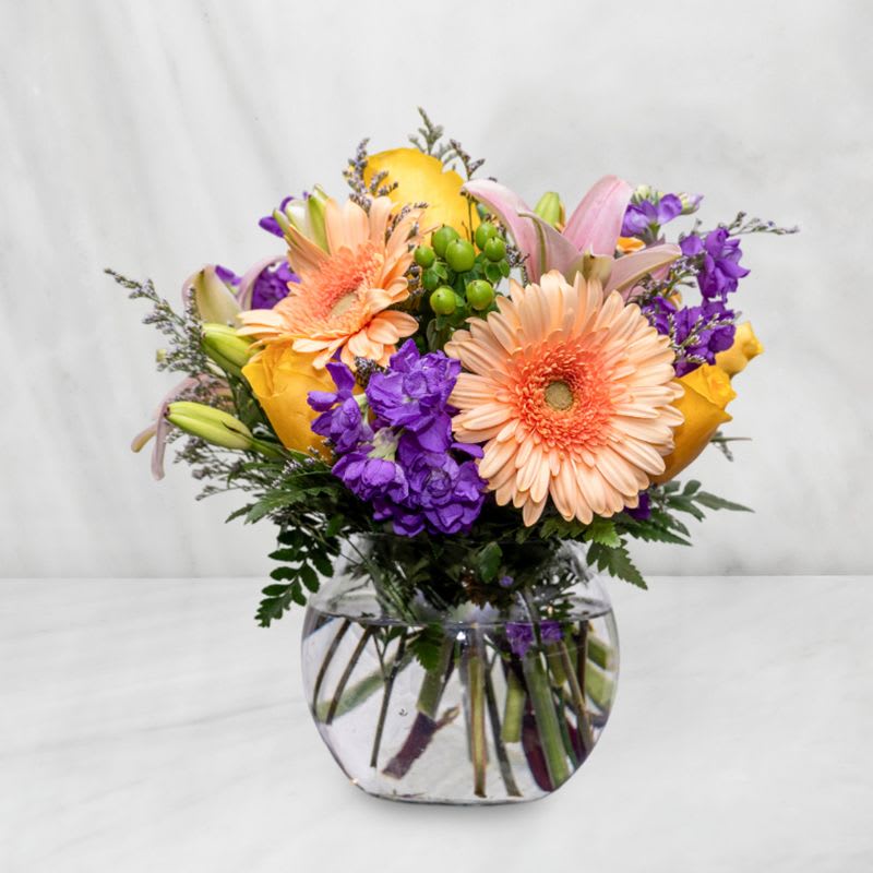 Pop of Pastels - A small, yet bold arrangement that will blow them away. It is a neat cube vase that is full of beautiful pastel flowers that is perfect for all occasions. Includes the favorites such as Lily's, Gerbera Daisies, Roses and more!