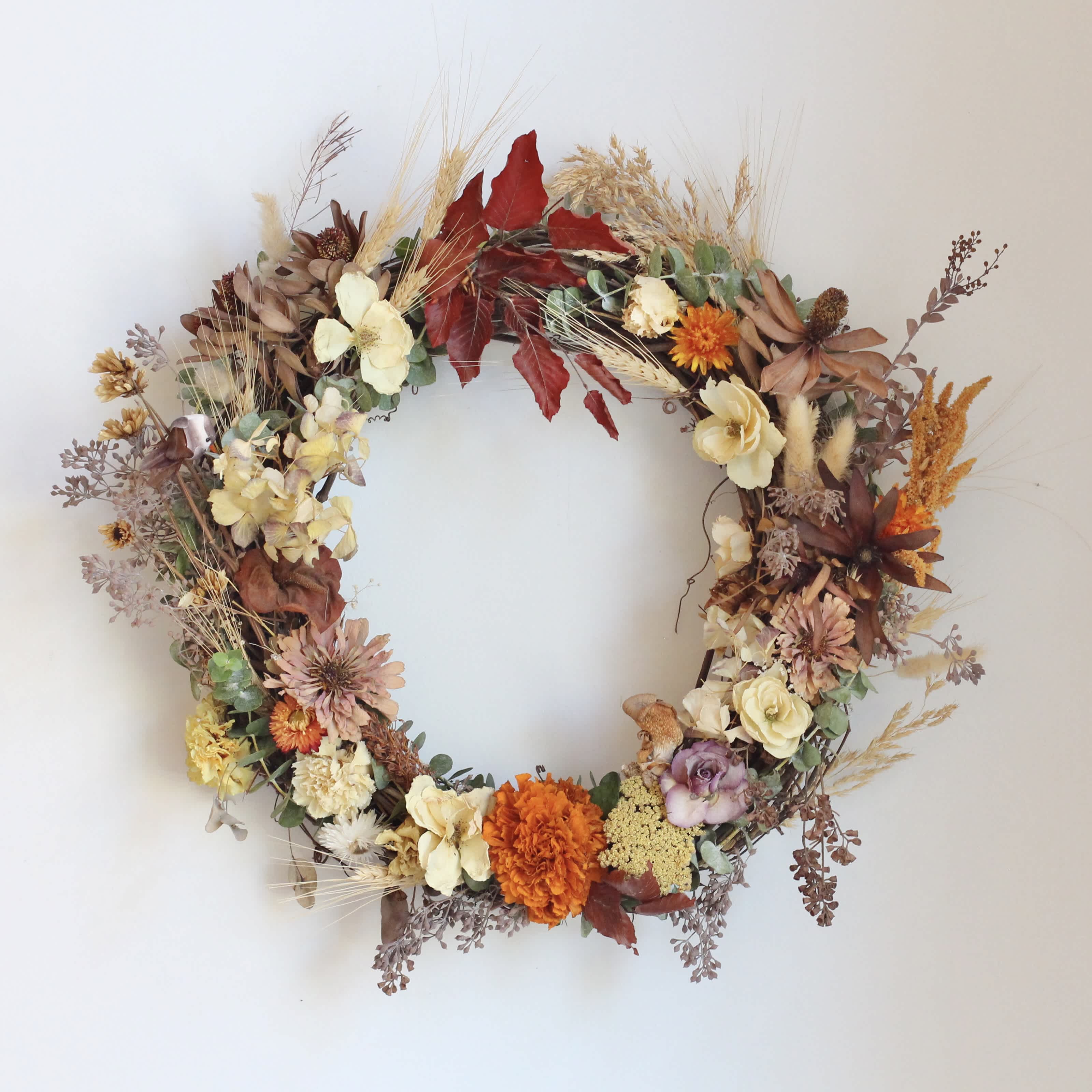Autumn floral wreath with cream, orange, and burgundy blooms