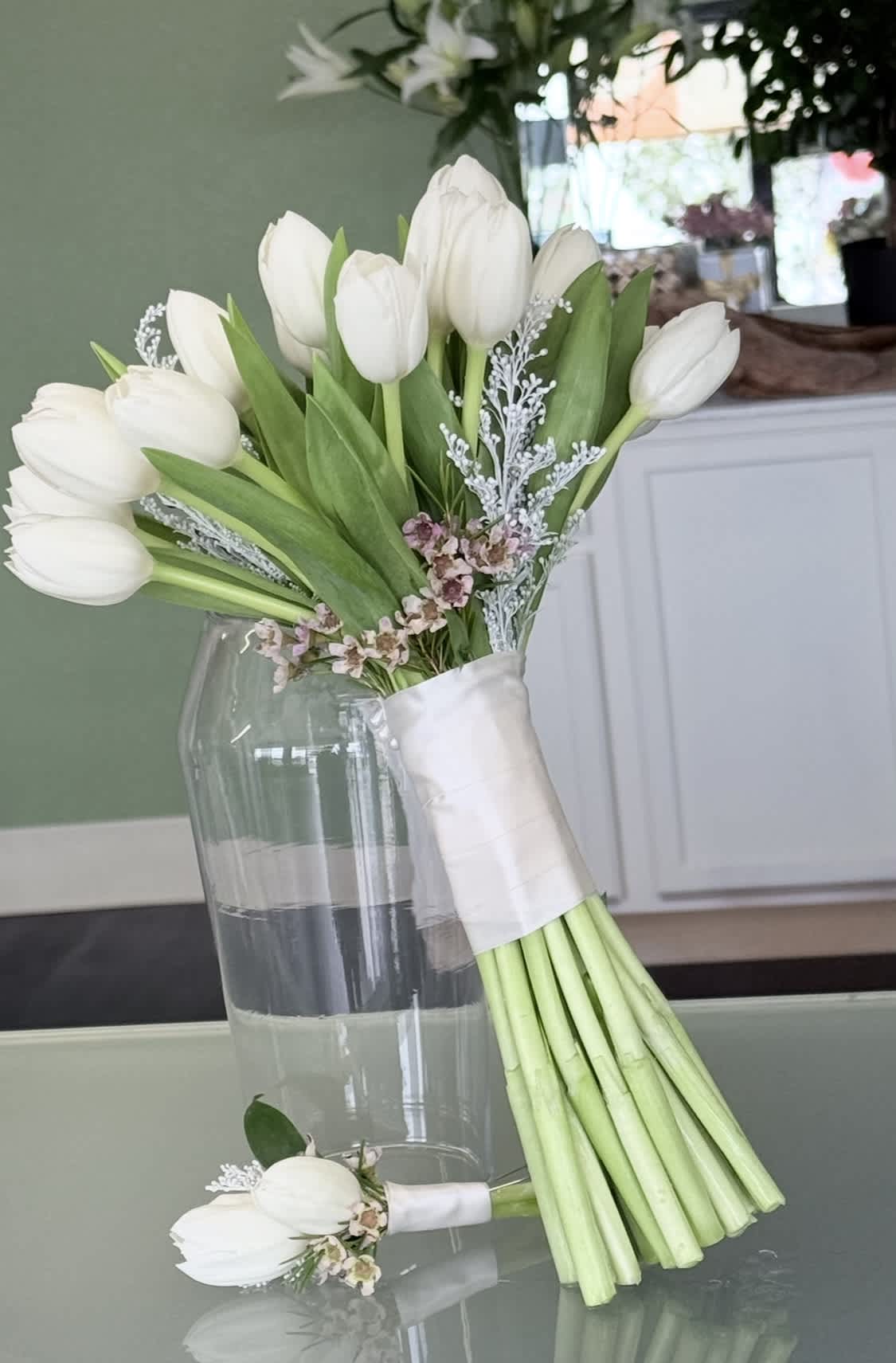White tulip bouquet with small pink filler flowers and a matching boutonniere