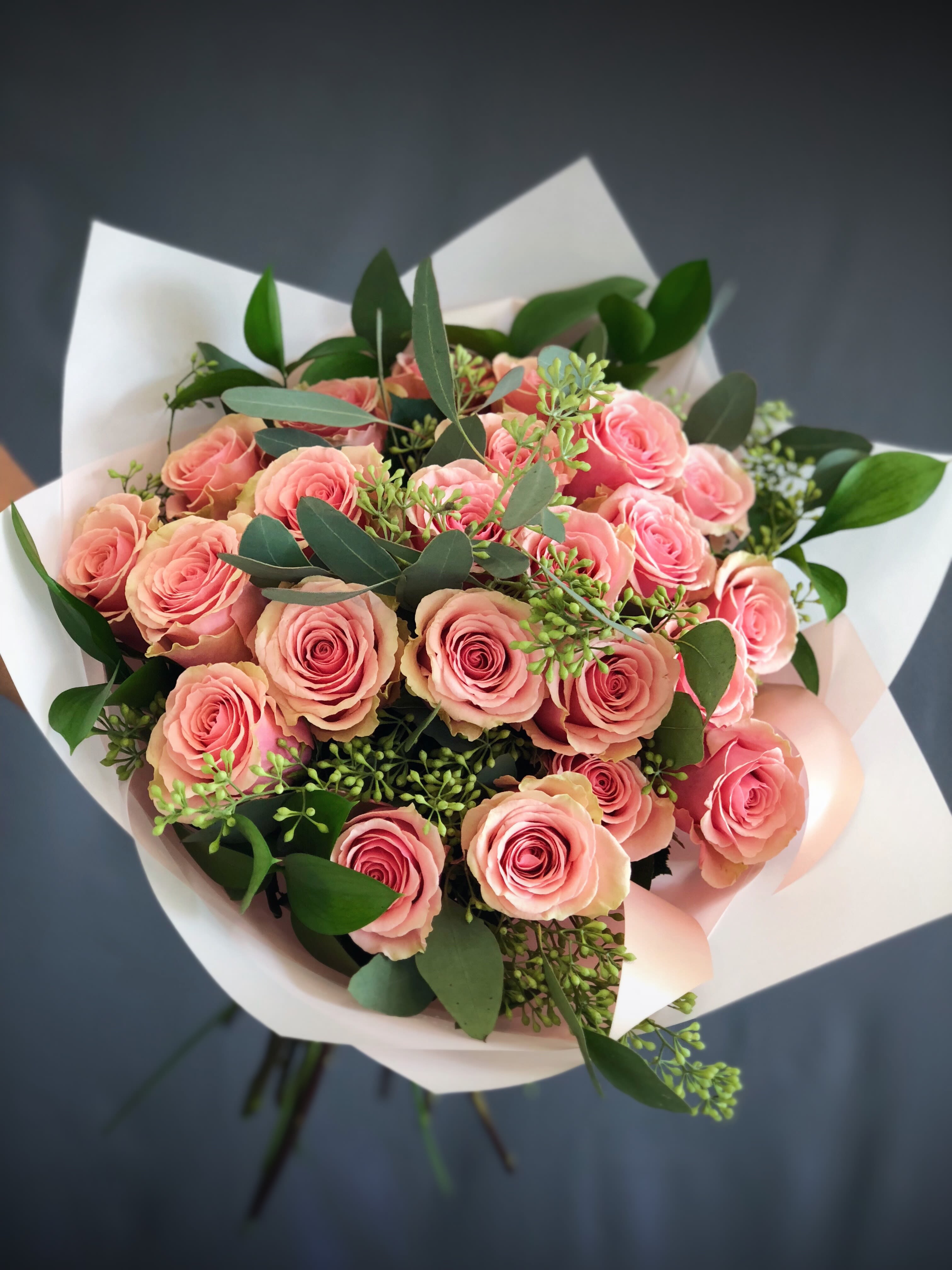 Bouquet of pink roses wrapped in white paper